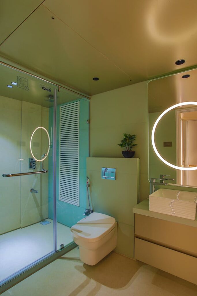 A bathroom with a toilet, sink and mirror